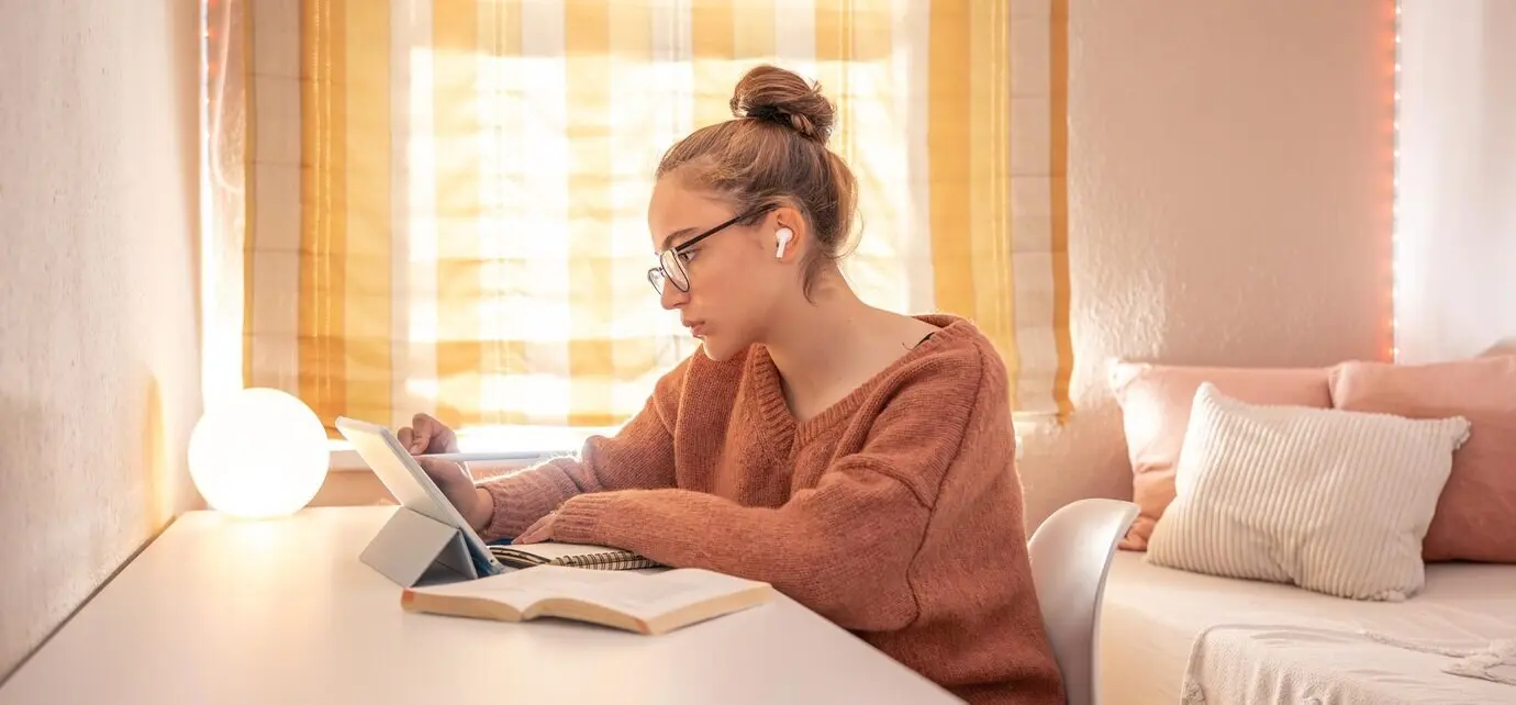 Eine Studentin führt zu Hause ein Telefongespräch.